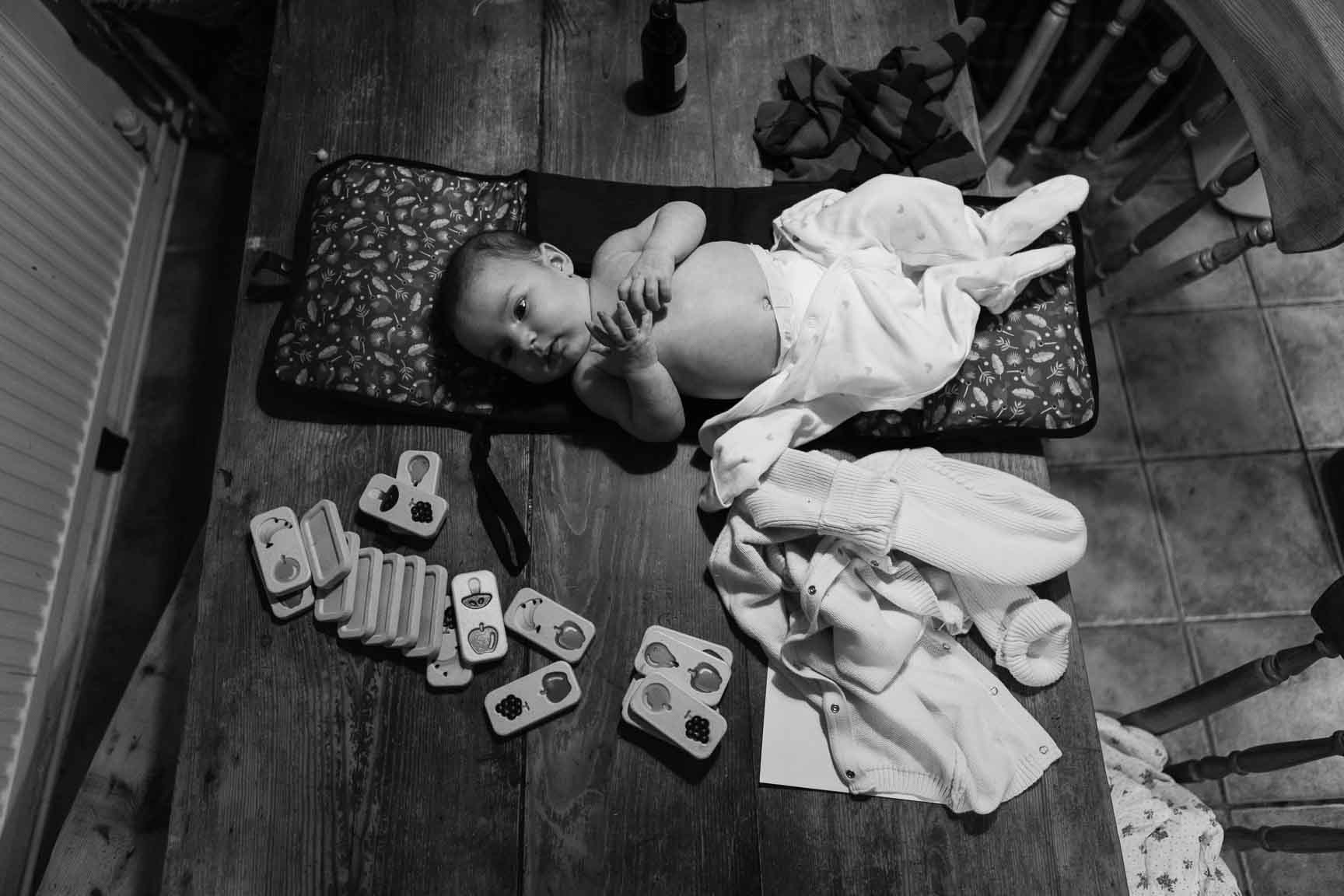 Baby lies half changed on table | Newborn Photographer Bath