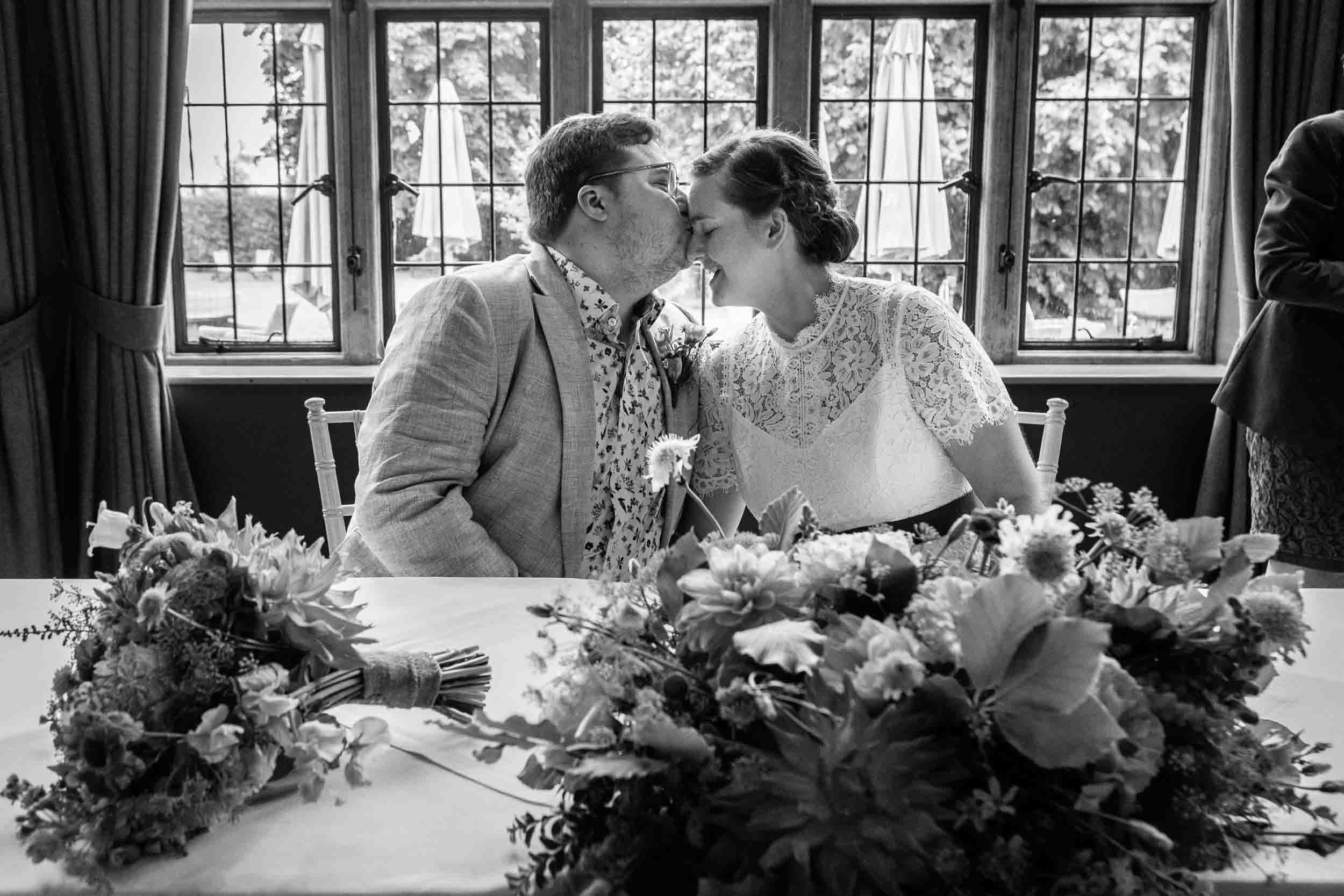 Groom kisses brides head after getting married at the Hare and Hound, Westonbirt, Bristol. Wedding Photographer Rose Dedman Photography
