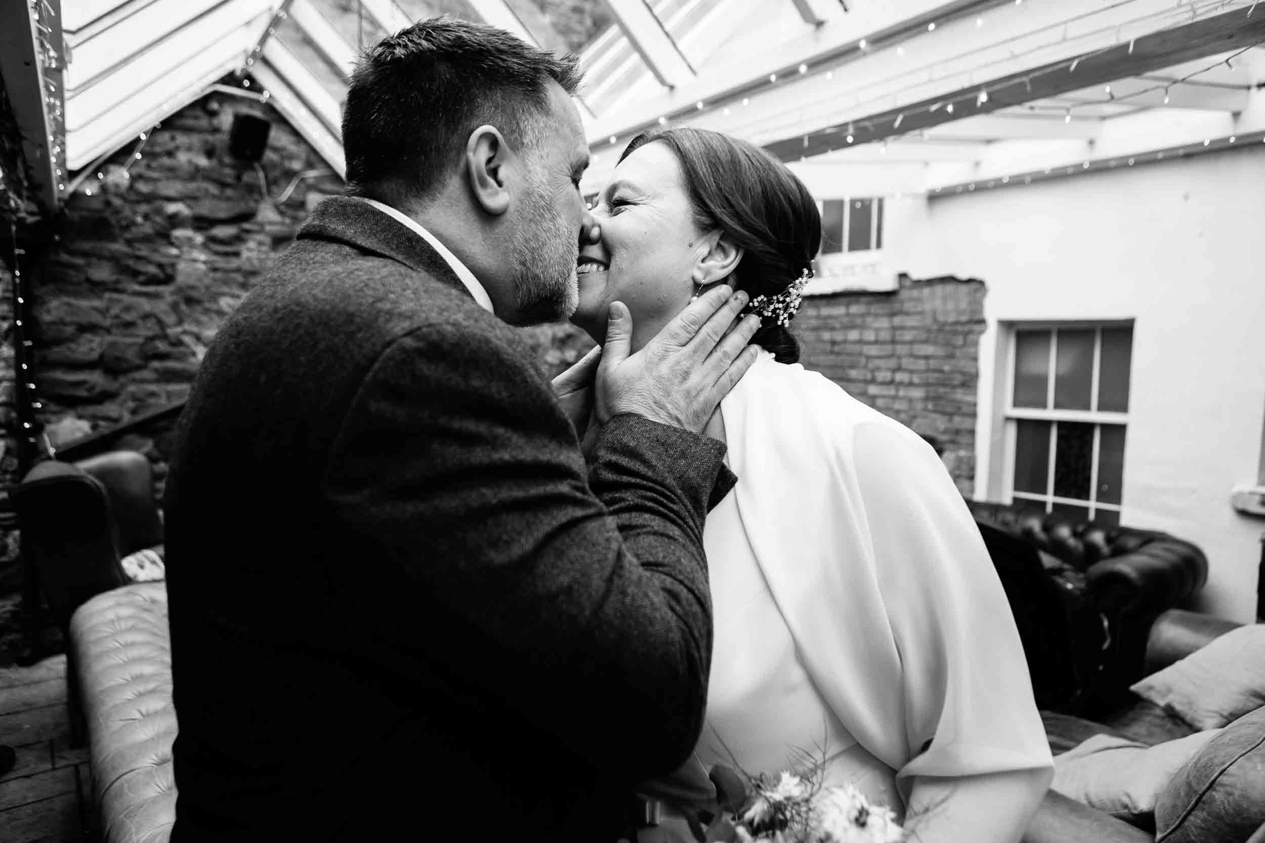 Bride and groom have a kiss after wedding ceremony at The Radnor Rooms, Bristol.