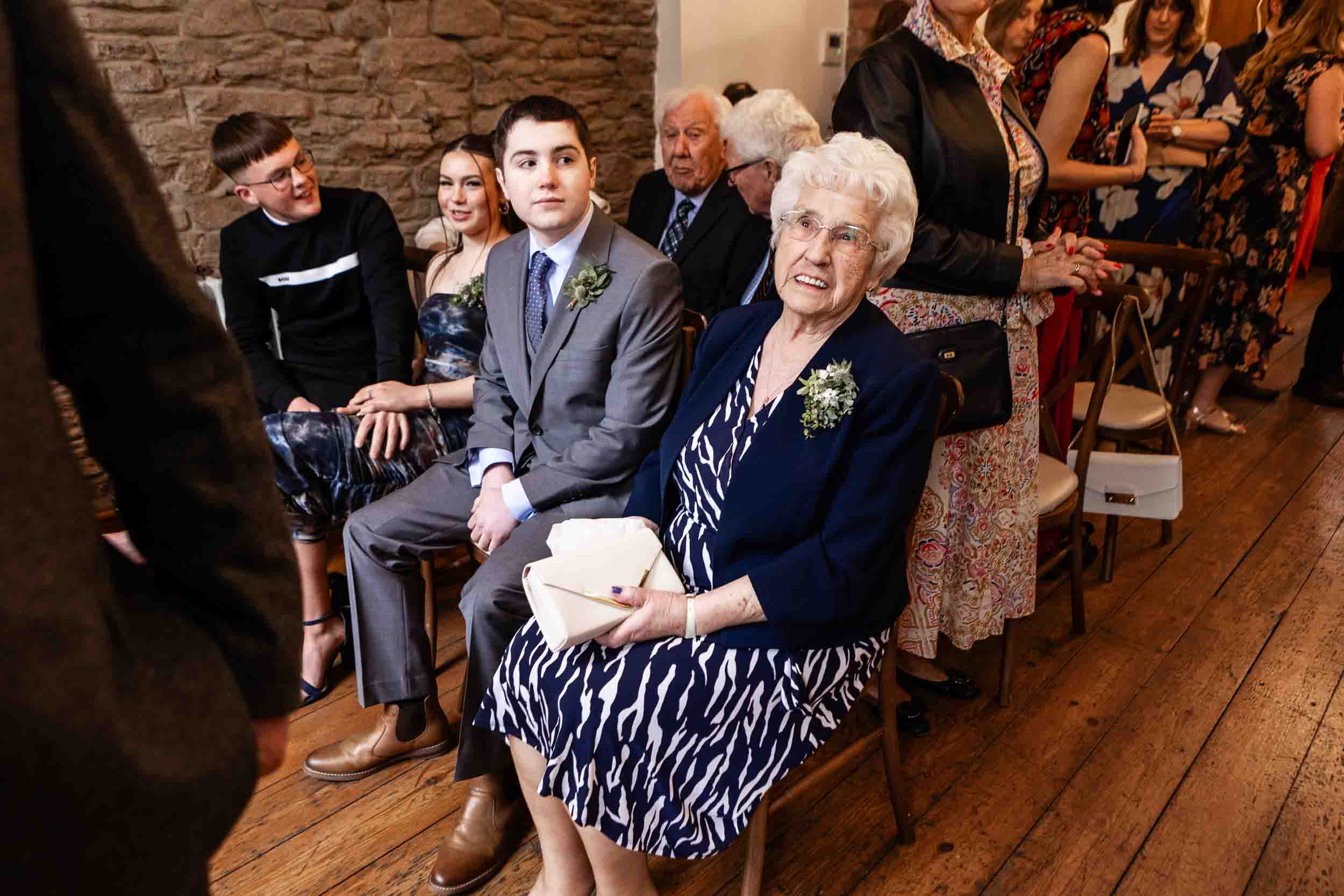 An older lady and a younger man wait ready for a wedding ceremony to start at The Radnor Rooms, Bristol.