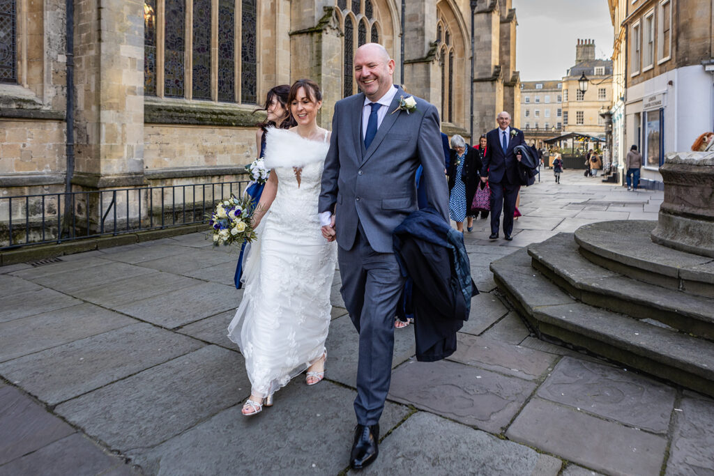 Wedding couple walking through Bath after their Bath Guildhall wedding | Rose Dedman Photography
