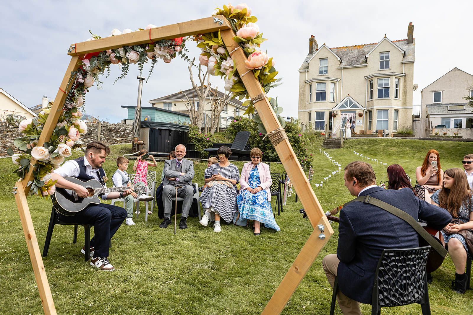 Groom playing guitar and guests at a coastal wedding | Rose Dedman Wedding Photographer UK