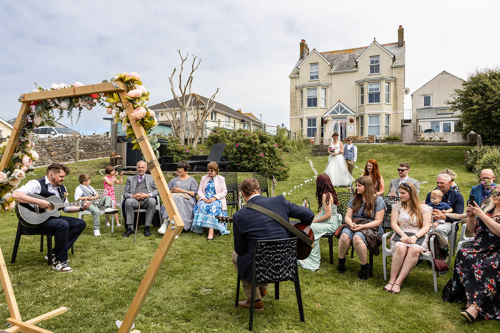 Groom playing guitar and guests at a coastal wedding | Rose Dedman Wedding Photographer UK