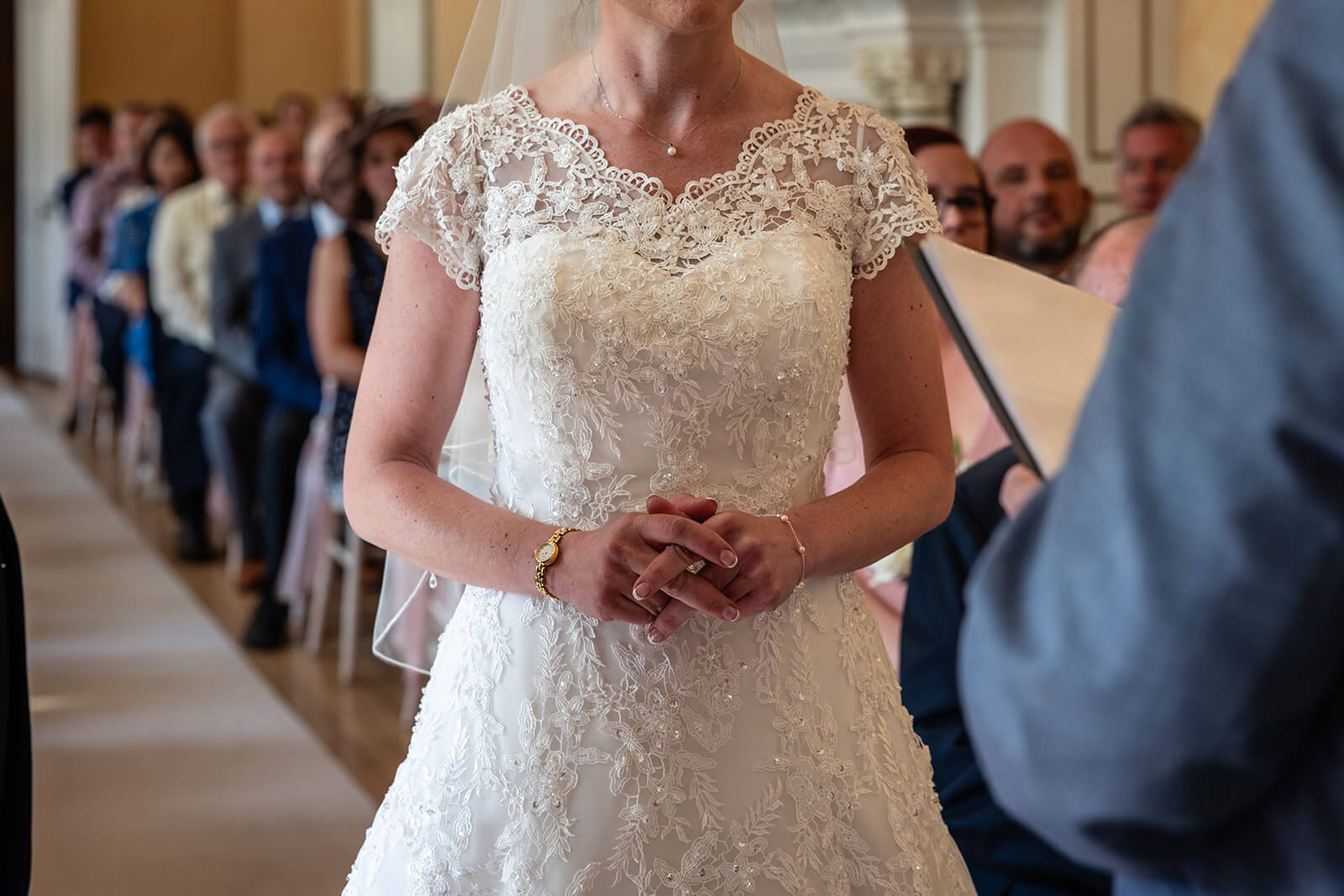 Bride in lace wedding gown at ceremony at Holmewood Hall  country house wedding venue in Cambridgeshire UK (not in Somerset). Rose Dedman wedding photographer.