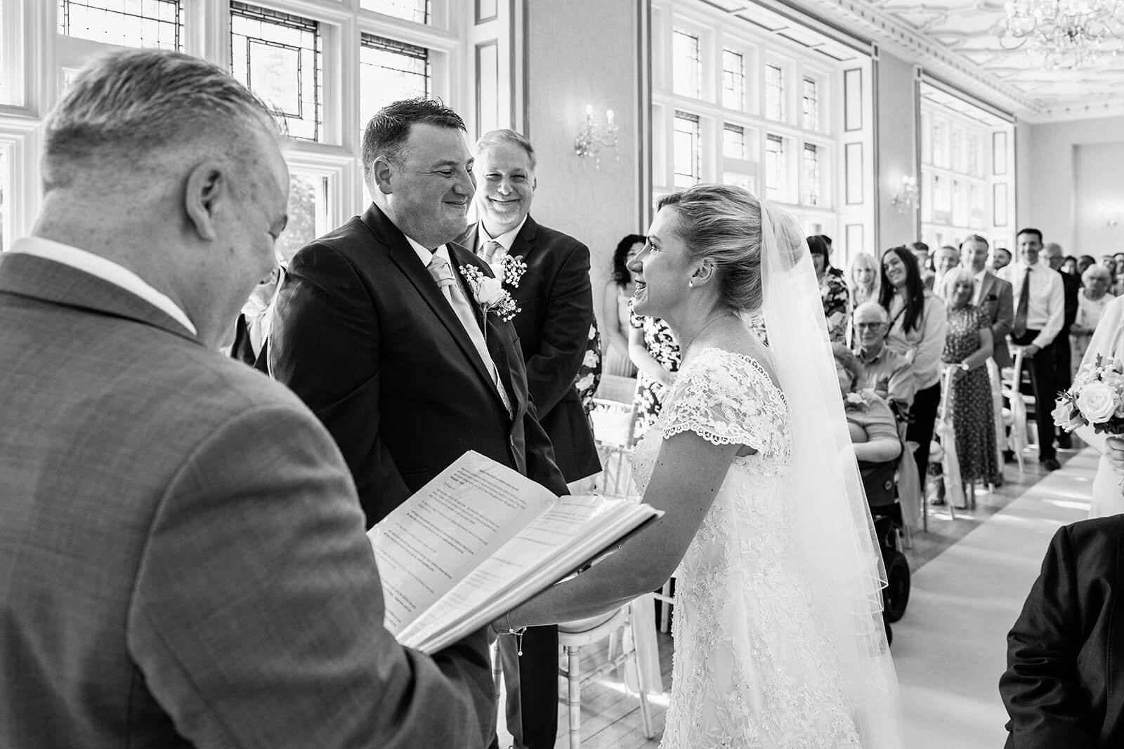 Bride and groom exchanging vows at their wedding at Holmewood Hall Cambridgeshire (not Somerset).