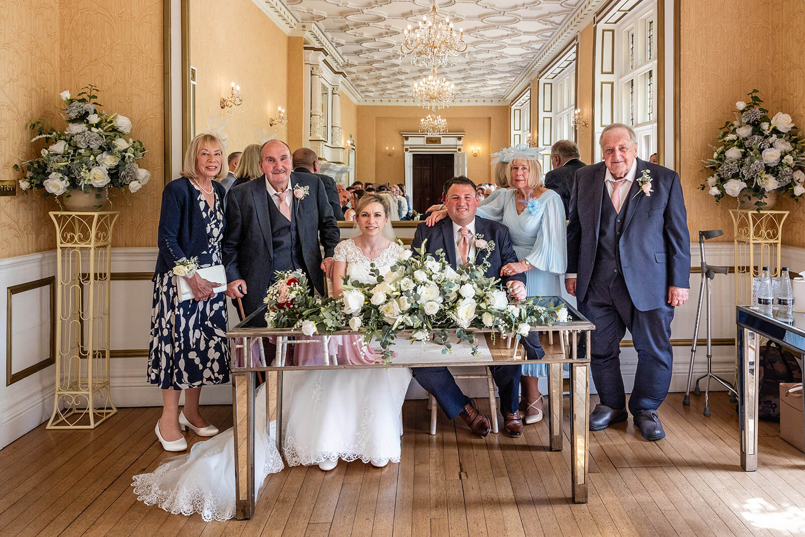 Wedding couple with family at ceremony table | Cotswold wedding photographer
