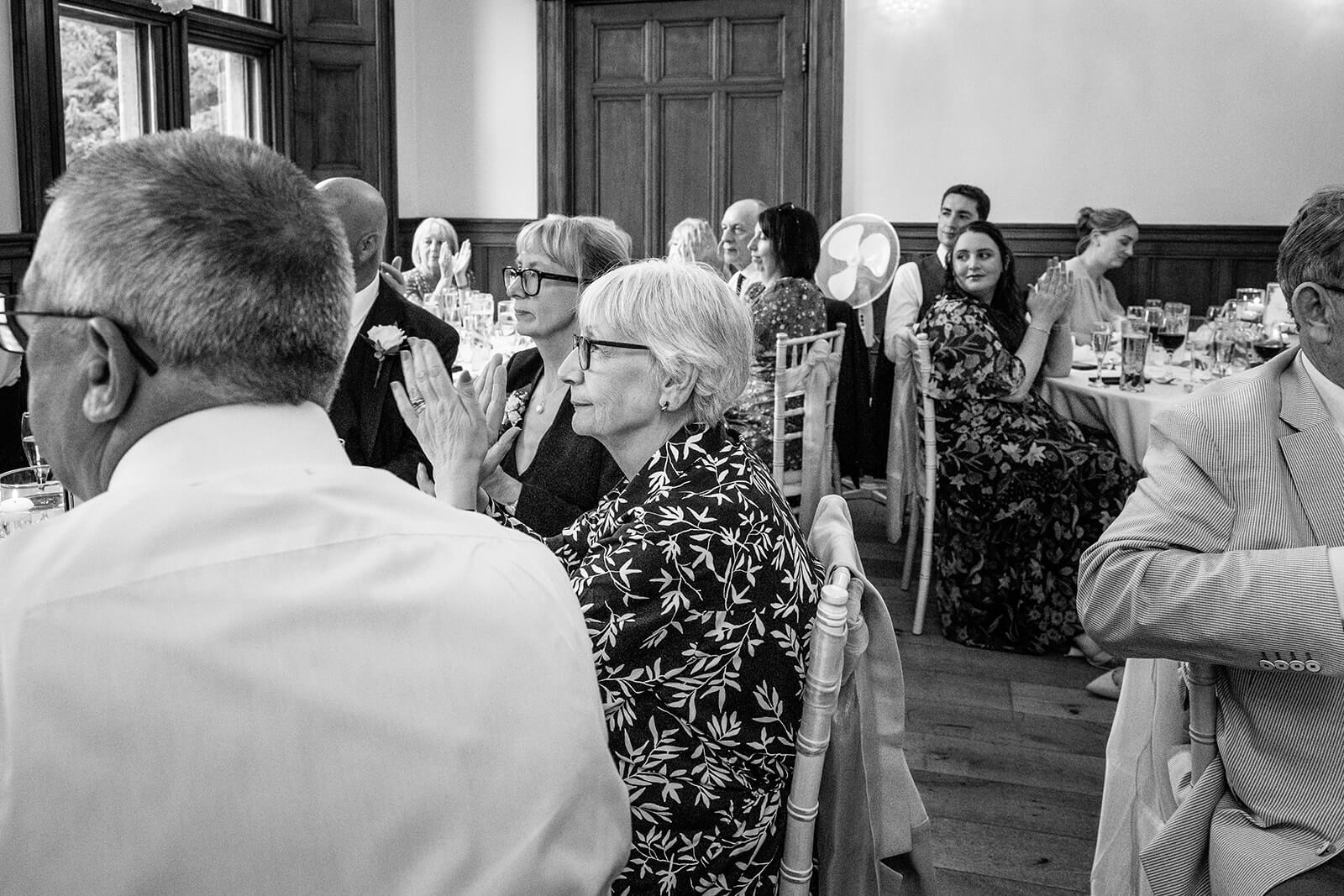 Guests clapping during wedding speeches at Holmewood House wedding.