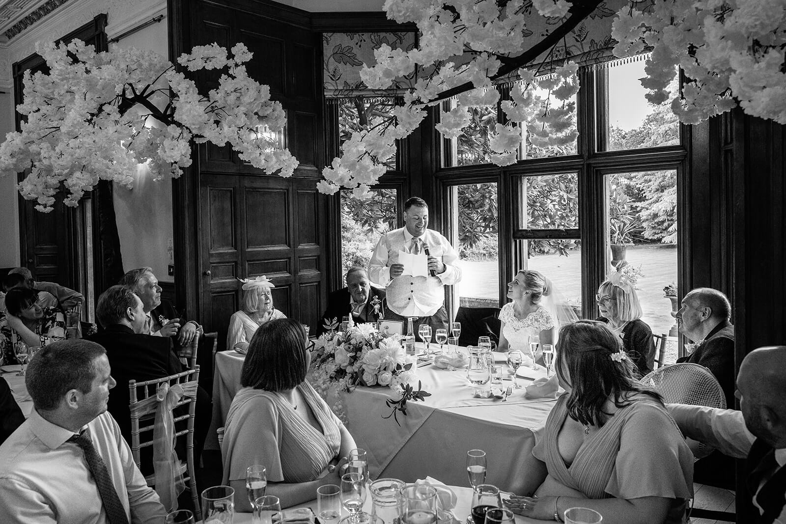Groom gives wedding speech at banquet table at Holmewood House wedding in Cambridgeshire (not Somerset) wedding. Somerset wedding photographer.