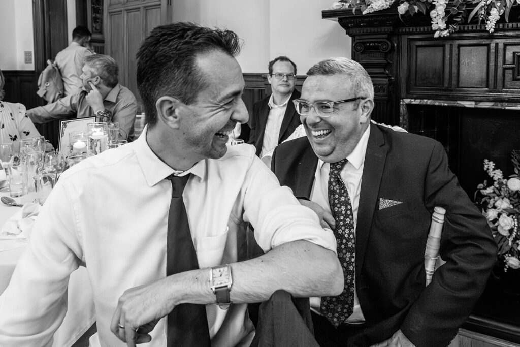 Two men laughing at a formal event.