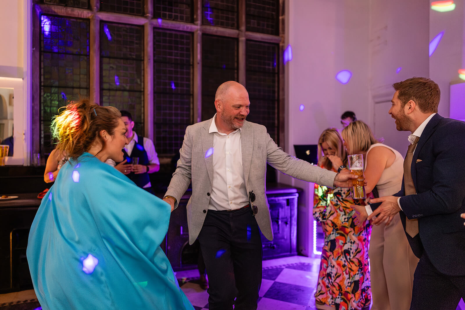 People dancing at a wedding party at Holmewood Hall, Cambridgeshire. Wedding Photographer Rose Dedman