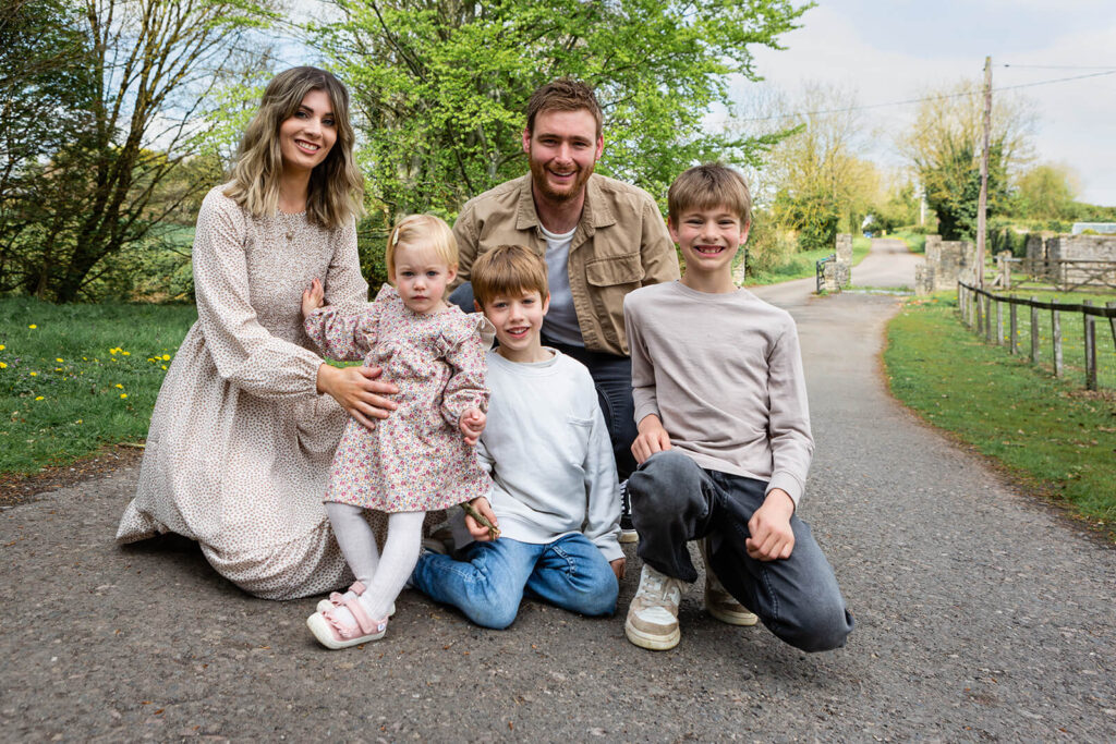 Family smiling outdoors on country lane