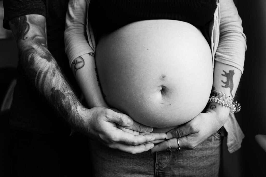 Pregnant belly with hands supporting underneath