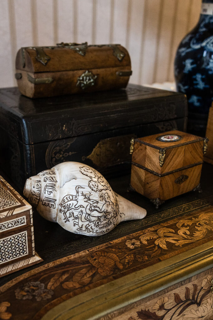Antique decorative boxes and carved conch shell displayed, at Pennard House wedding venue in Somerset, UK. By Pennard House UK wedding photographer Rose Dedman.