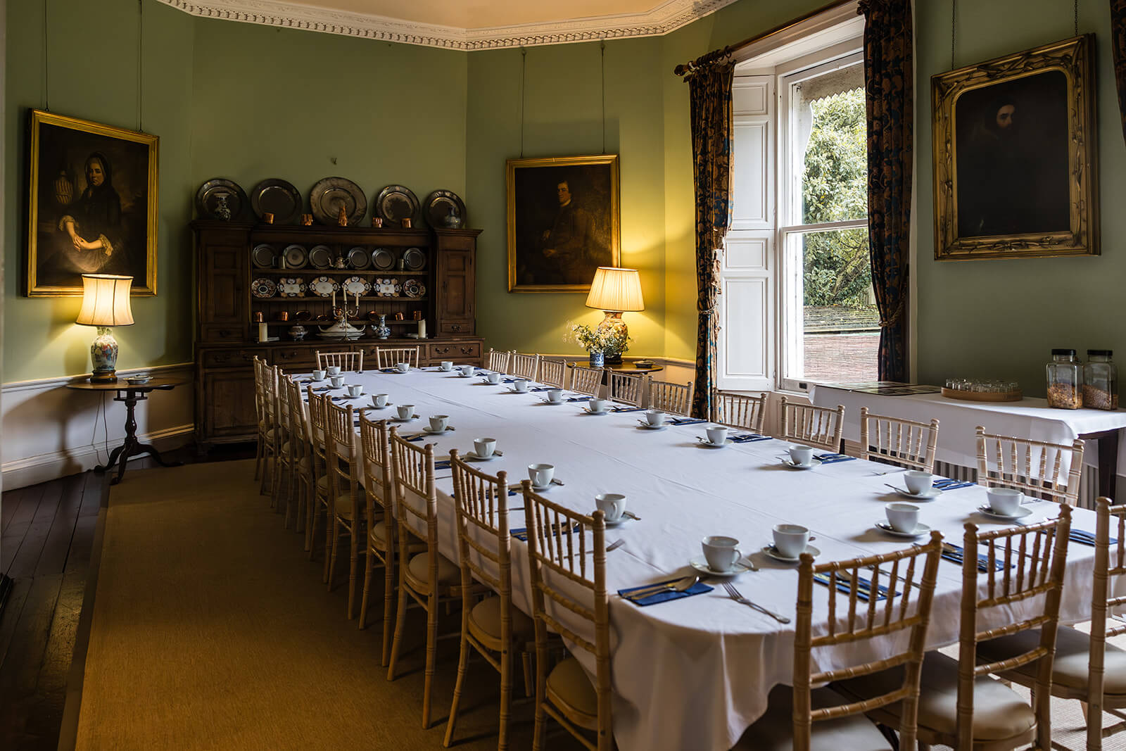 Elegant dining room with a long set table at Pennard House in Somerset, UK. By UK wedding photographer Rose Dedman.
