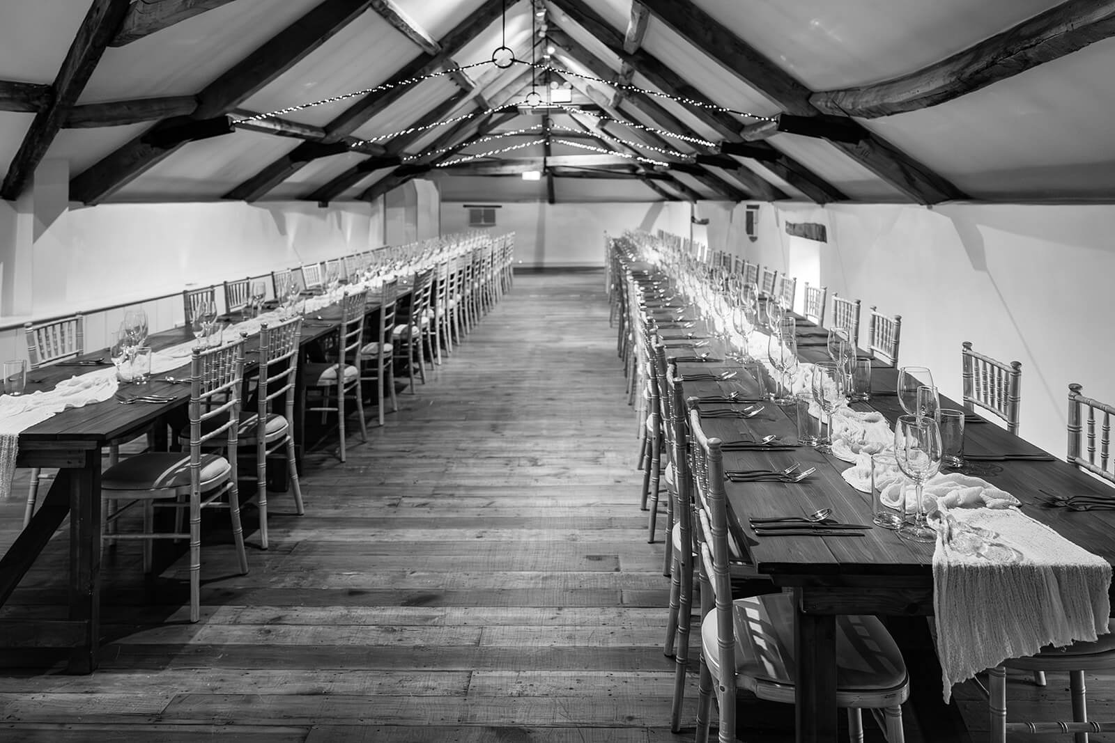 Rustic wedding reception tables in elegant loft venue at Pennard House wedding venue, Somerset. Rose Dedman Photography.