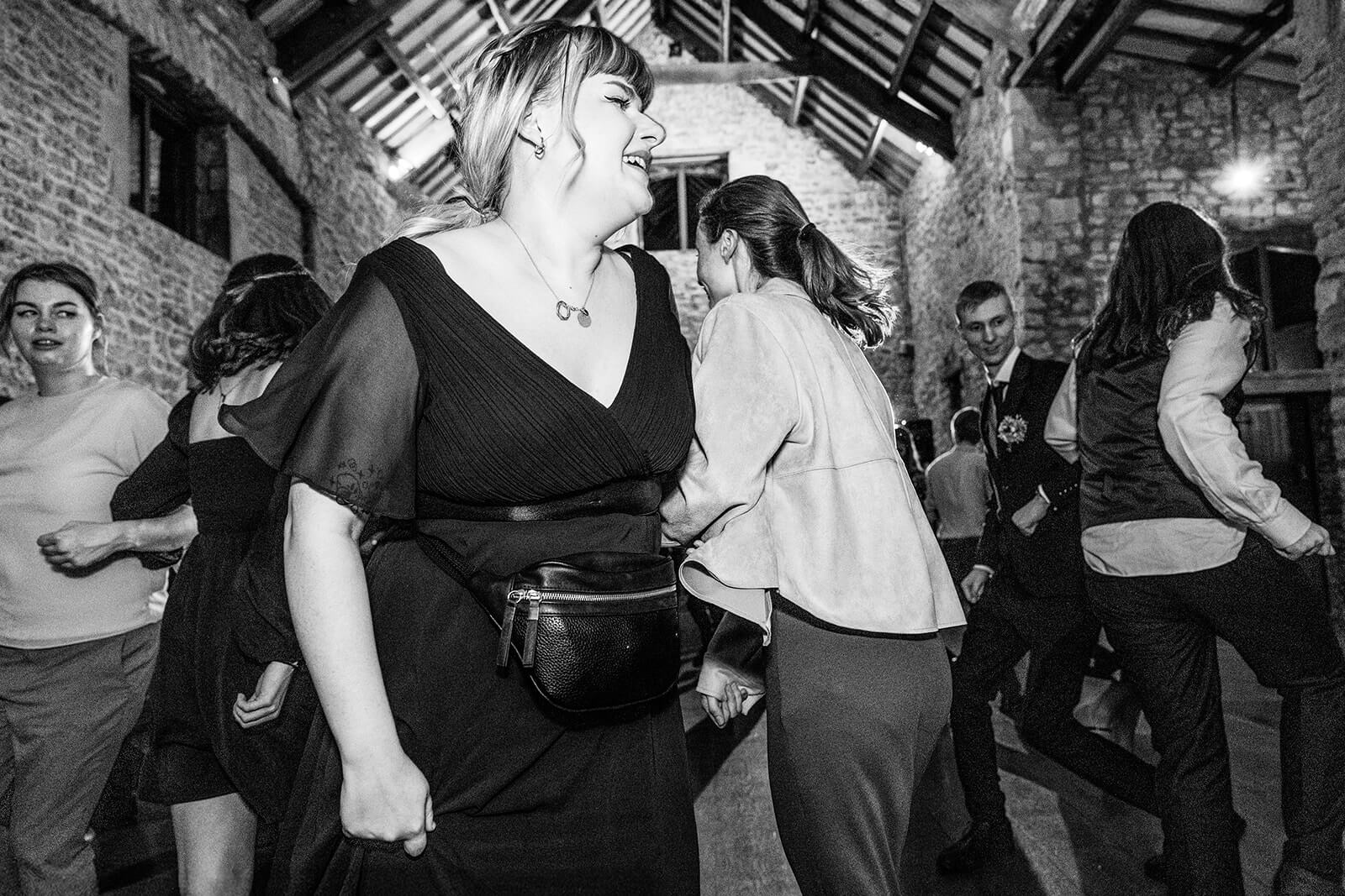 People dancing joyfully at a wedding evening party at Priston Mil near Bath | Priston Mill wedding photographer Rose Dedman.