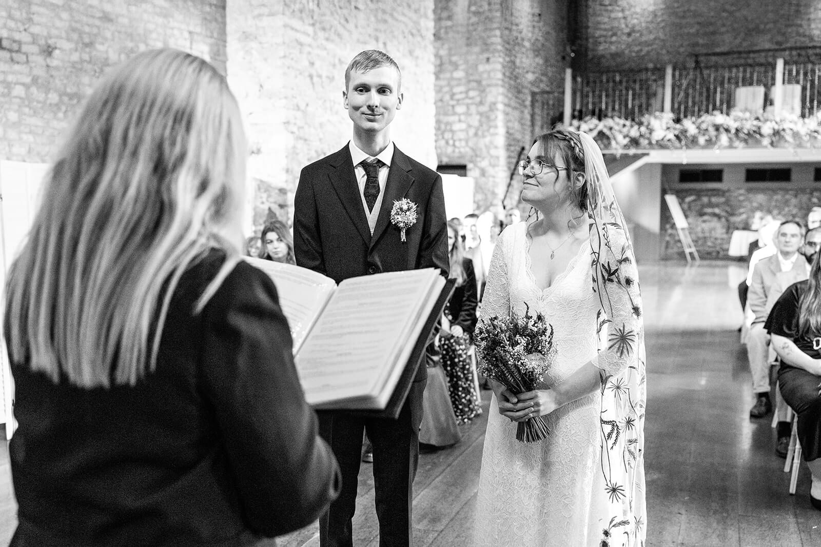 Bride looking at the groom during a wedding ceremony at Priston Mill Tythe Barn | Priston Mill wedding photographer | Rose Dedman