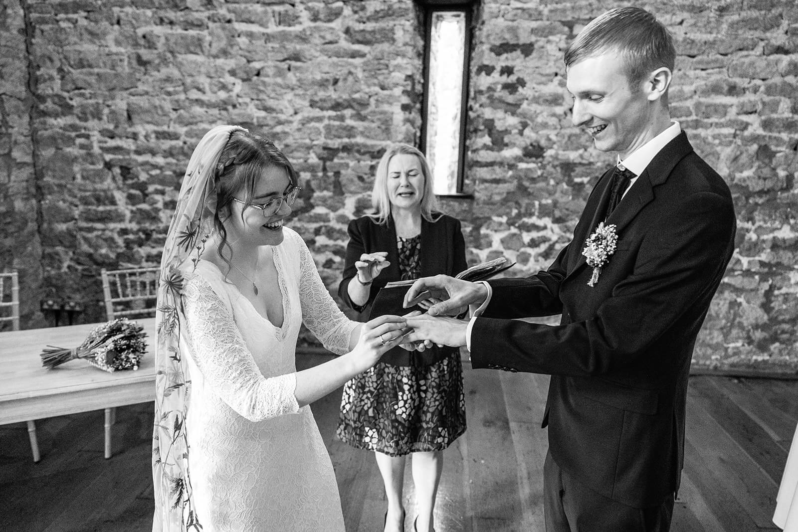 Bride and groom exchanging rings during wedding ceremony at Priston Mill near Bath, UK. | Priston Mill wedding photographer.