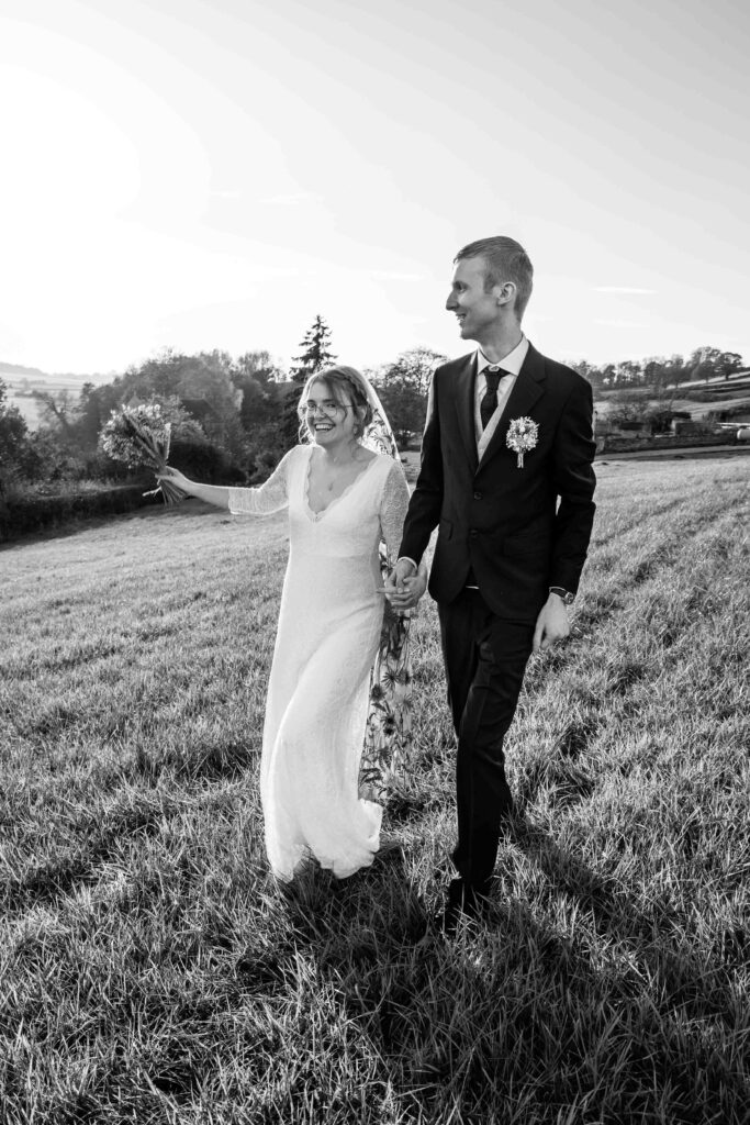 Happy couple walking in field | The Newt wedding photographer.
