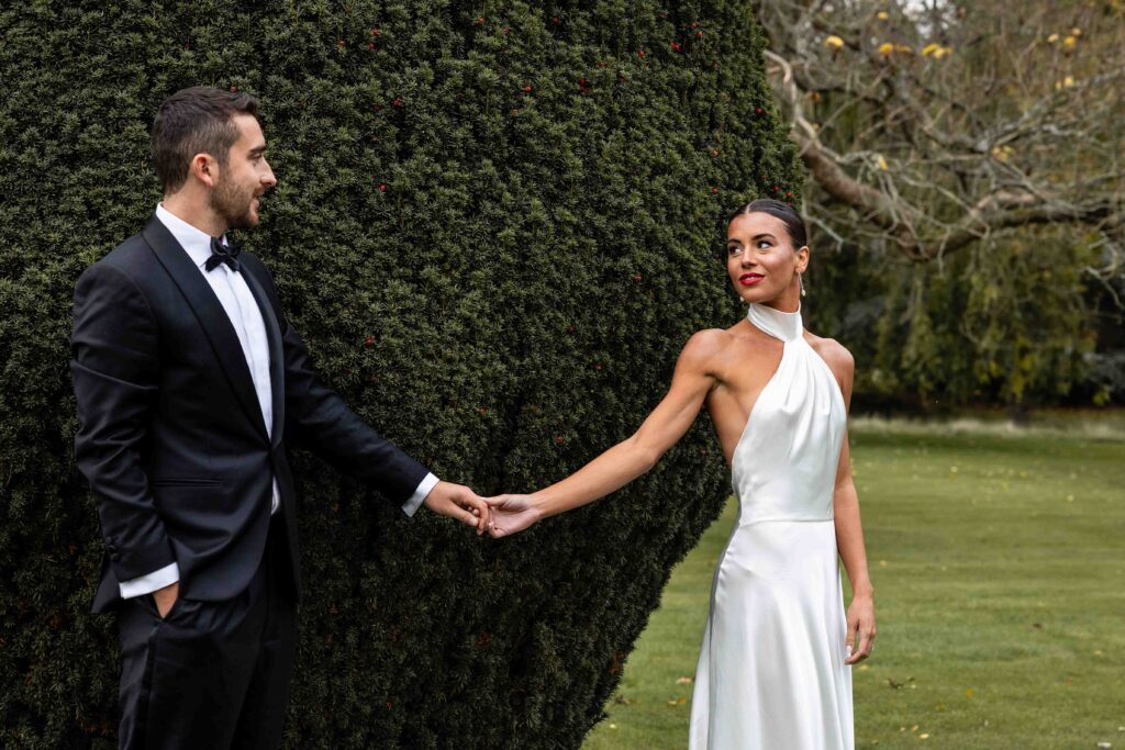 Couple in formal attire holding hands outdoors | The Newt wedding photographer.