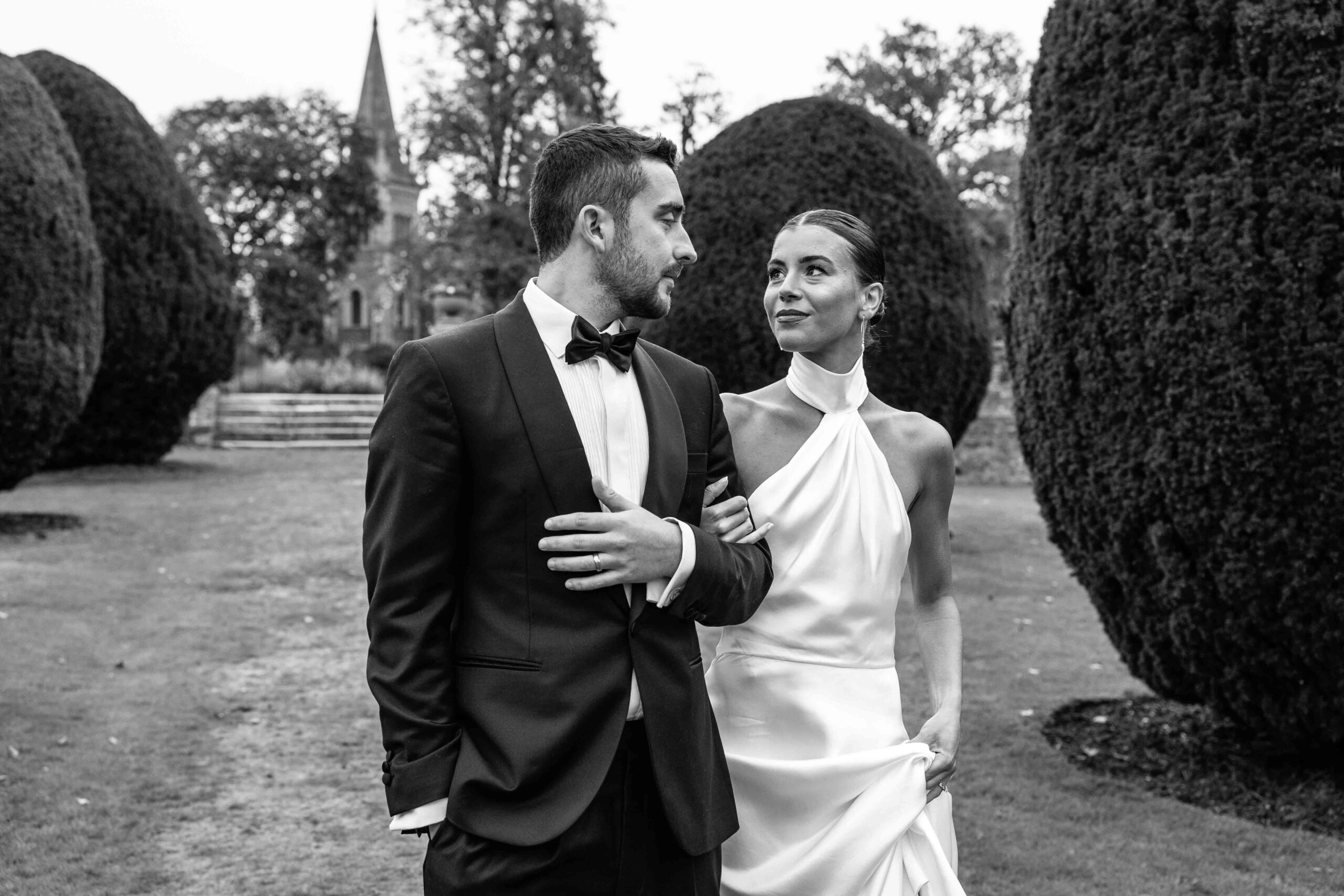 Elegant couple in formal attire walking together outside at The Elvetham | The Elvetham wedding photographer.