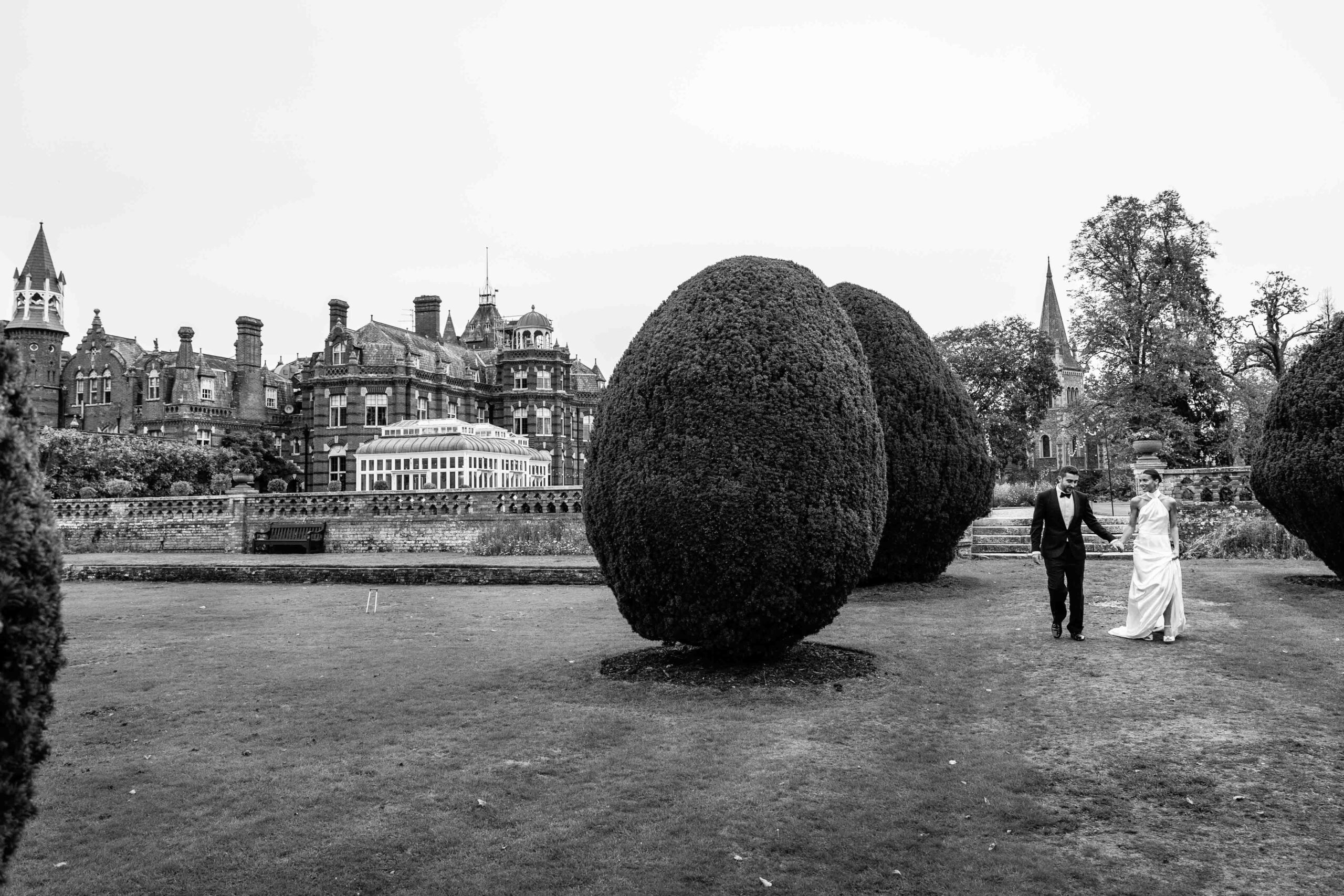 Bride and groom walking in front of The Elvetham Estate | Elvethem Estate wedding photographer.