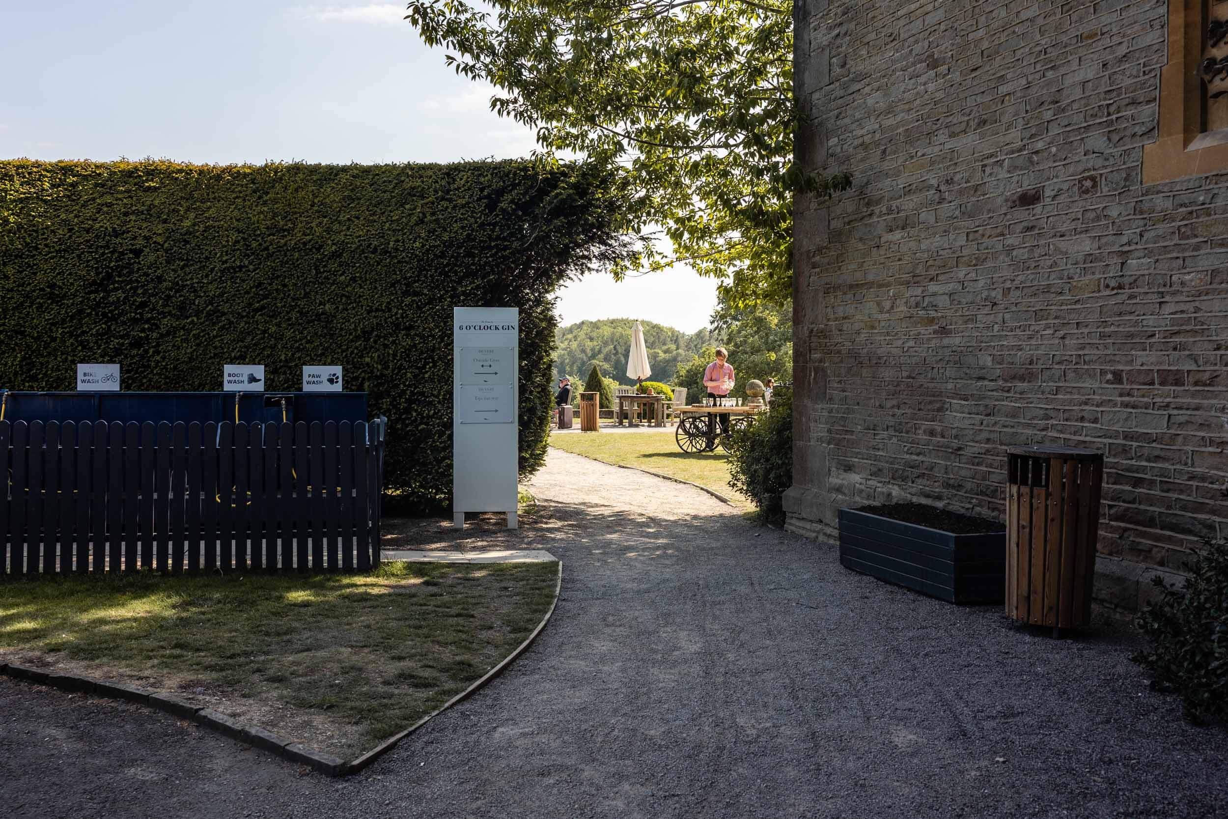 Garden entrance with people and outdoor seating at Tortworth Court | Tortworth Court Wedding Photographer Rose Dedman