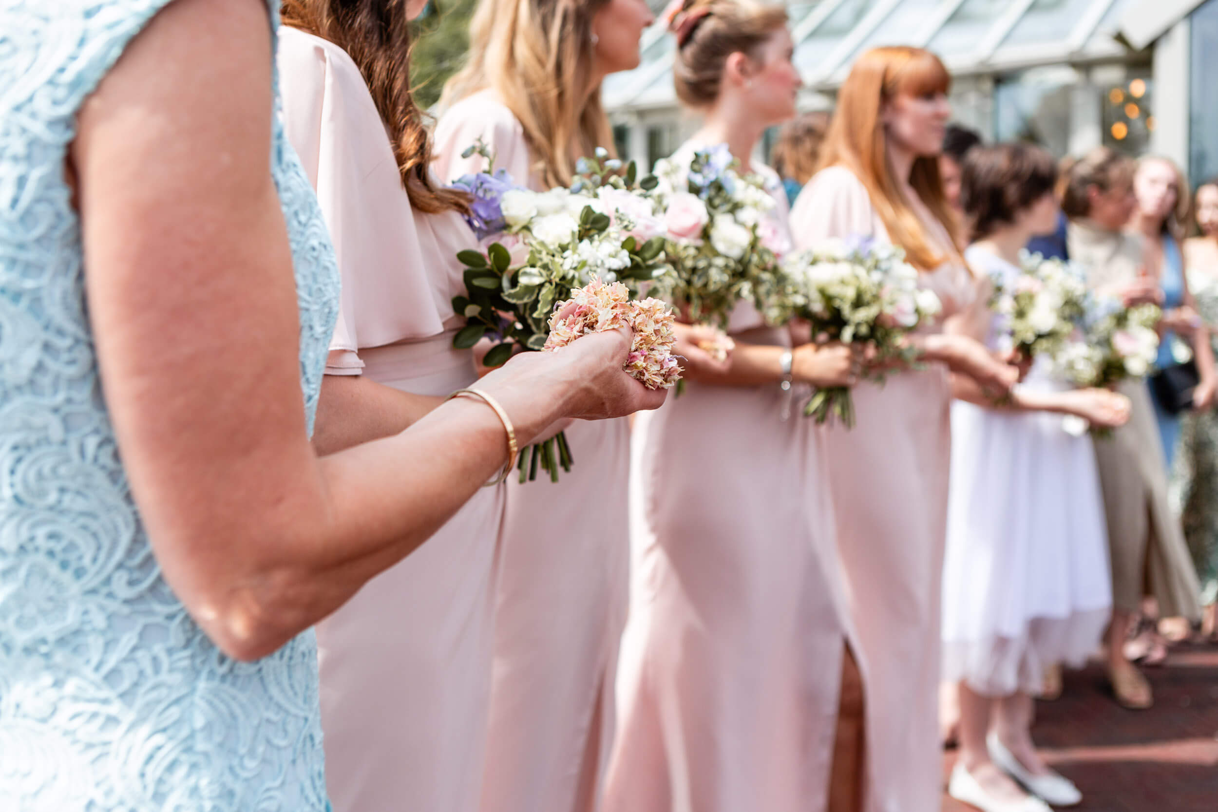 Bridesmaids holding bouquets and confetti at Syrencot wedding.