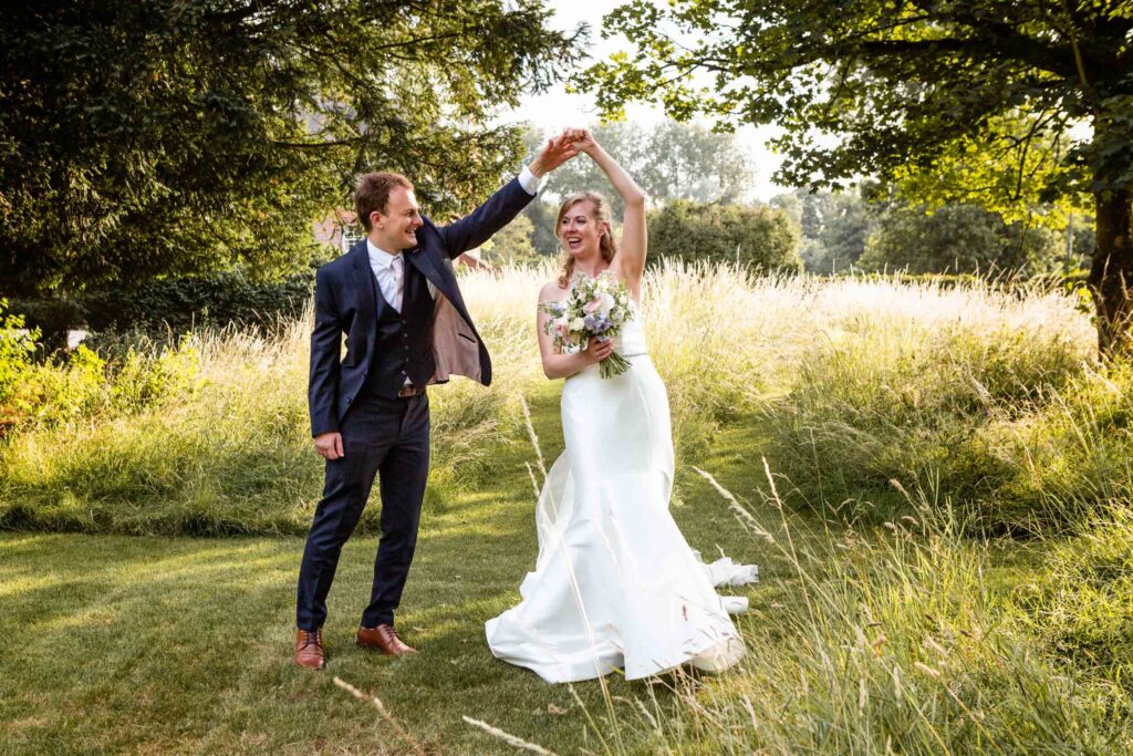 Bride and groom dancing in sunny garden
