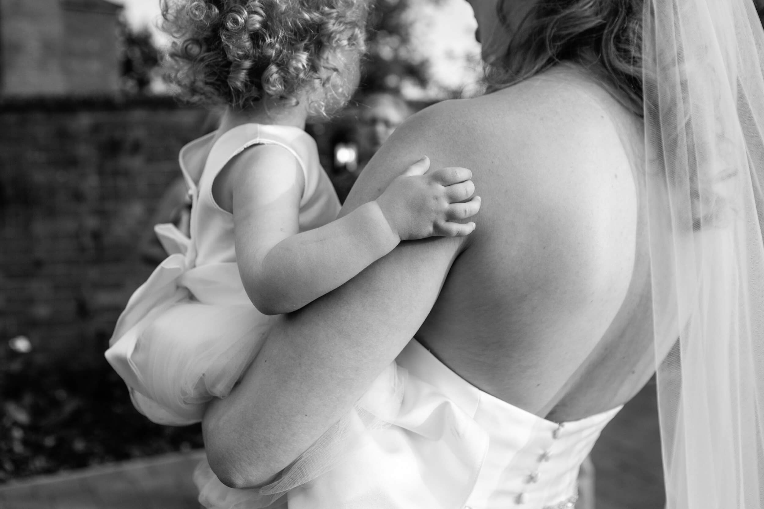 Bride holding child with curly hair | Syrencot House Wedding Photographer