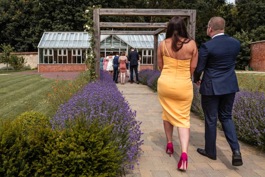 Guests walking towards a garden wedding venue