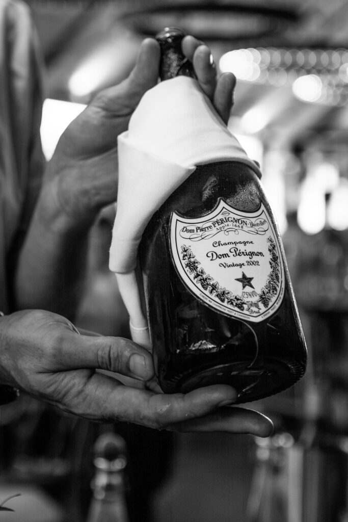 Close-up of vintage champagne bottle in hands | The Newt wedding photographer.