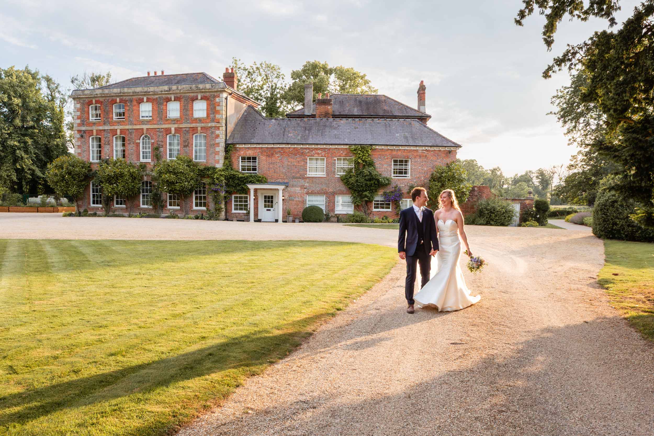 Bride and groom walking by Syrencot wedding venue | Syrencot wedding photographer
