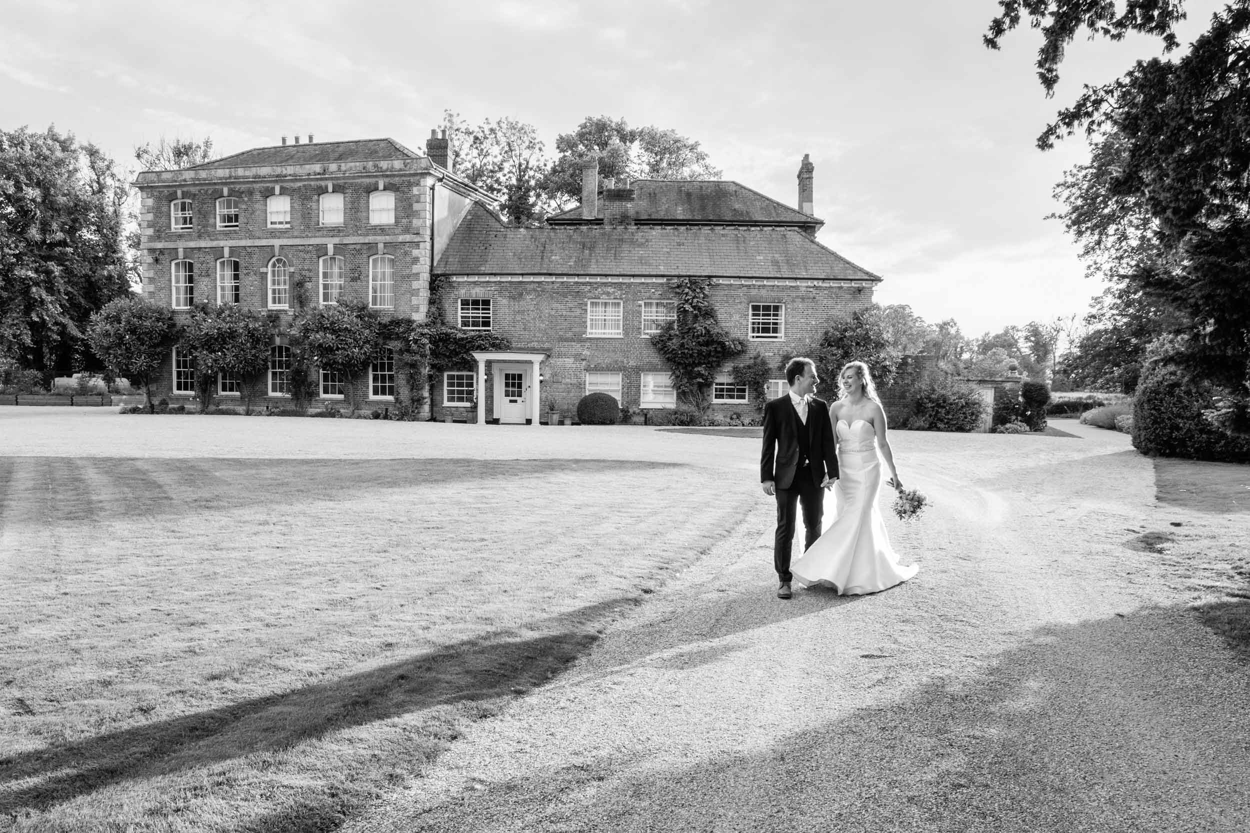 Bride and groom walking by Syrencot wedding venue | Syrencot wedding photographer