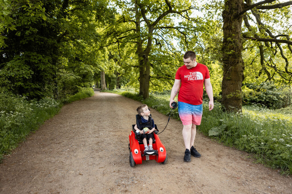Child in red car on park path