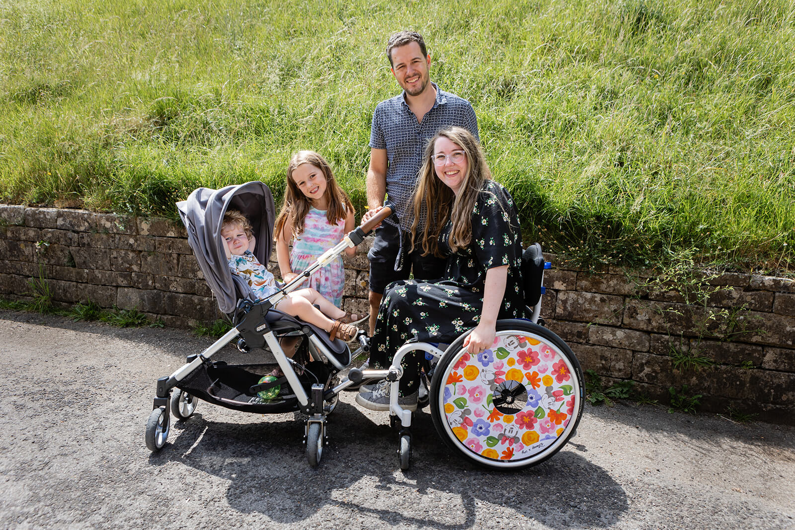Family with wheelchair and pushchair outdoors during a charity photography session | Charity photographer Rose Dedman