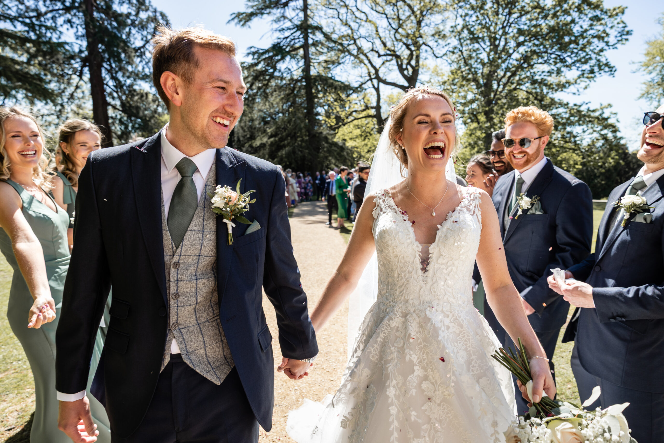 Bride and groom laughing with wedding party | Planning Your Wedding Photography at Pennard House