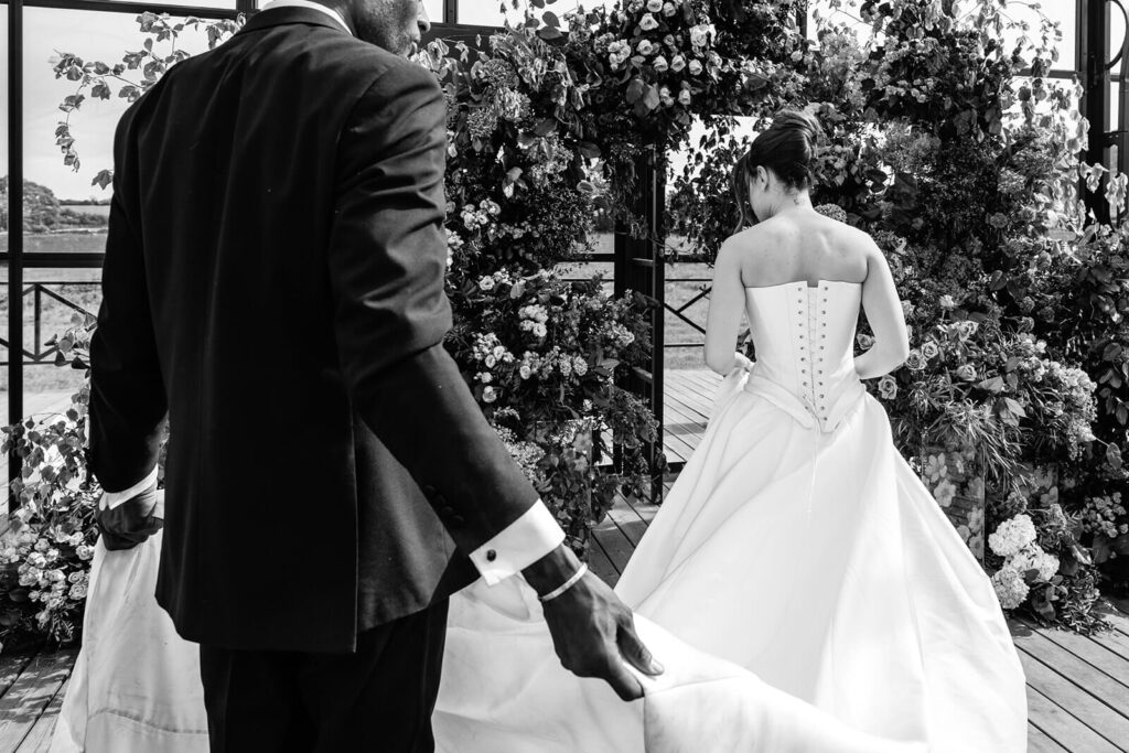 Bride and groom at floral wedding arch