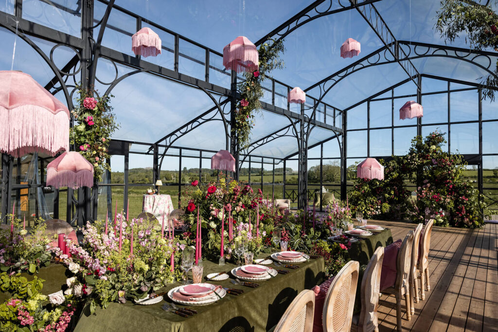Elegant greenhouse dining with pink decor.