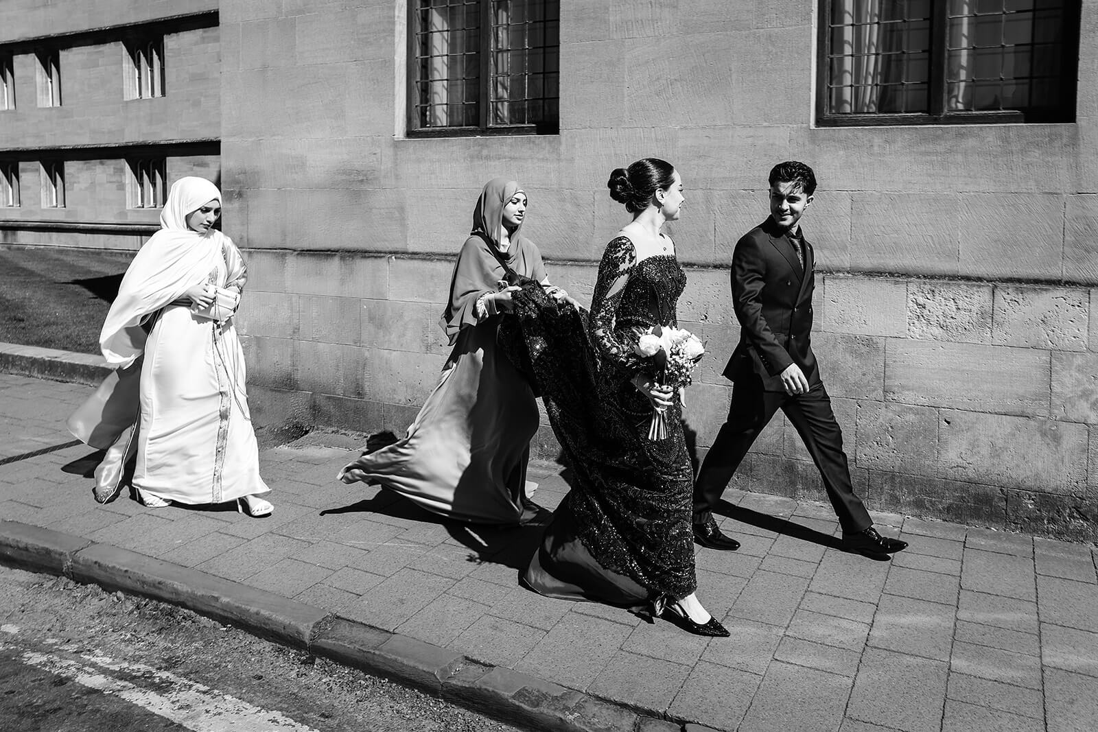 Elegant group walking on sunny street in central Oxford | Oxford Nikkah Wedding Photos