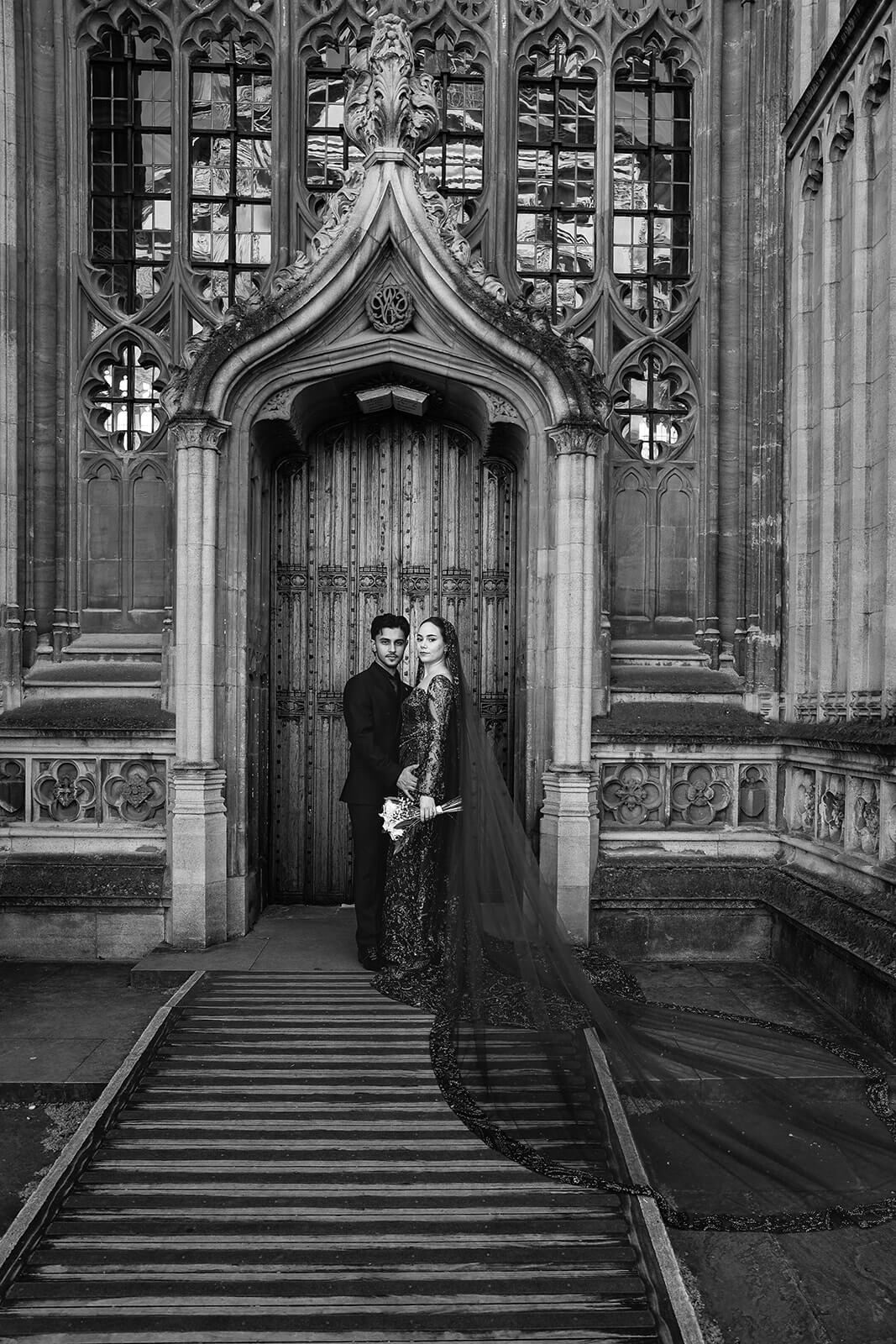 Bride and groom in Nikkah attire by ornate doorway | Oxford Nikkah Wedding Photos