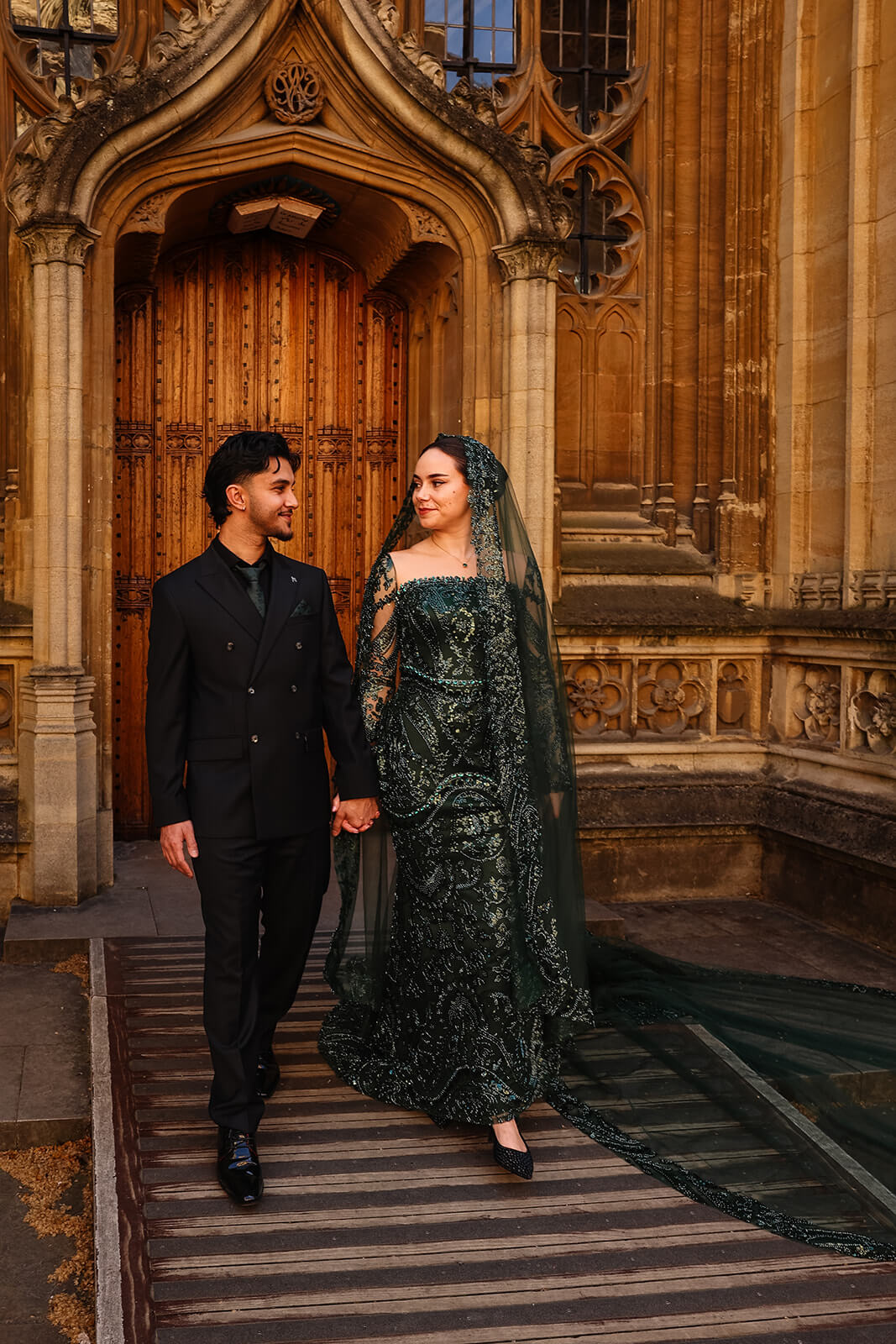 Bride and groom in Nikkah attire by ornate doorway | Oxford Nikkah Wedding Photos