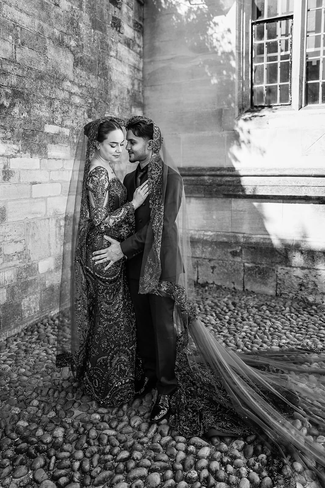 Bride and groom in traditional Nikkah attire standing together under a veil | Oxford Nikkah wedding photographer