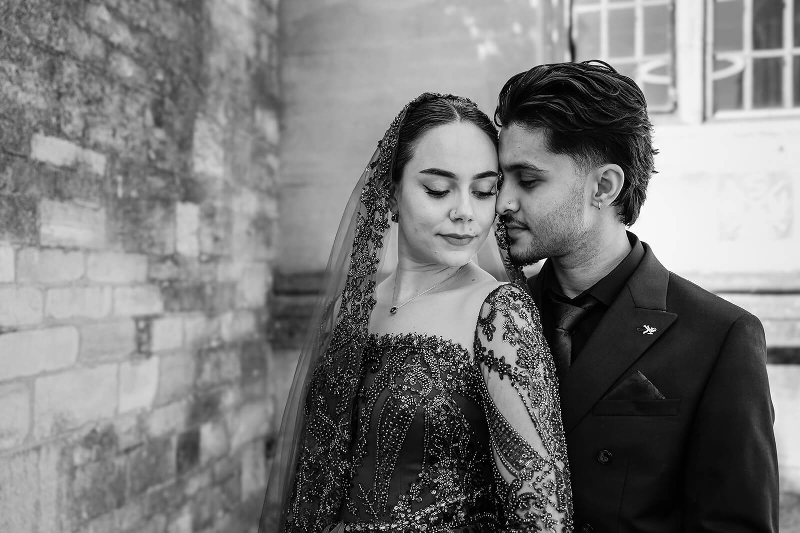 Elegant couple in embroidered attire embracing | Oxford Nikkah wedding photos