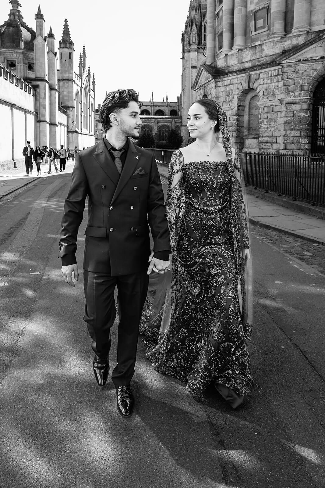 Couple walking, historic building backdrop | Oxford Nikkah wedding photos