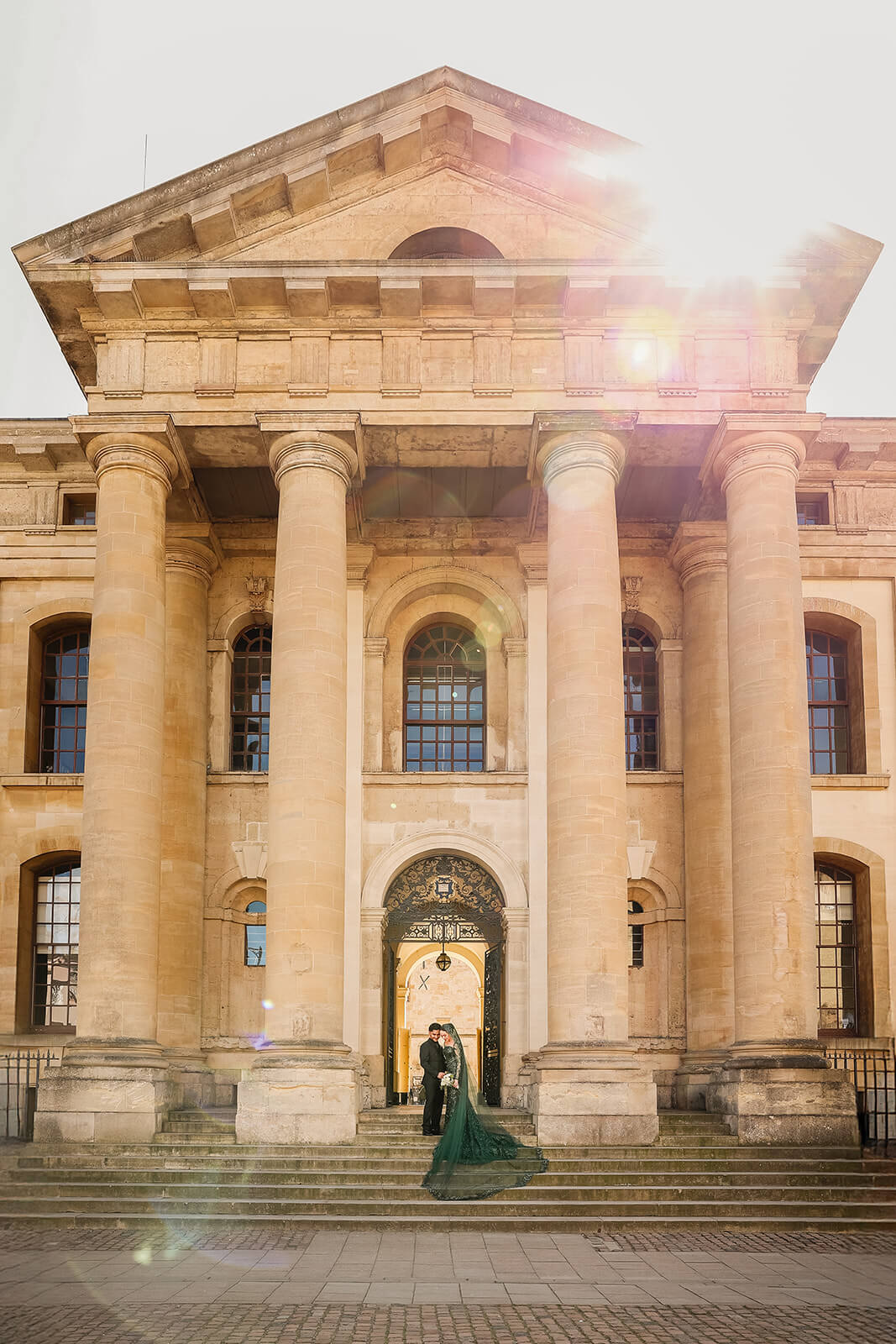 Entrance to the Bodleian Library building in central Oxford with a Nikkah wedding couple on the steps about to get married | Bodleian Library wedding photographer