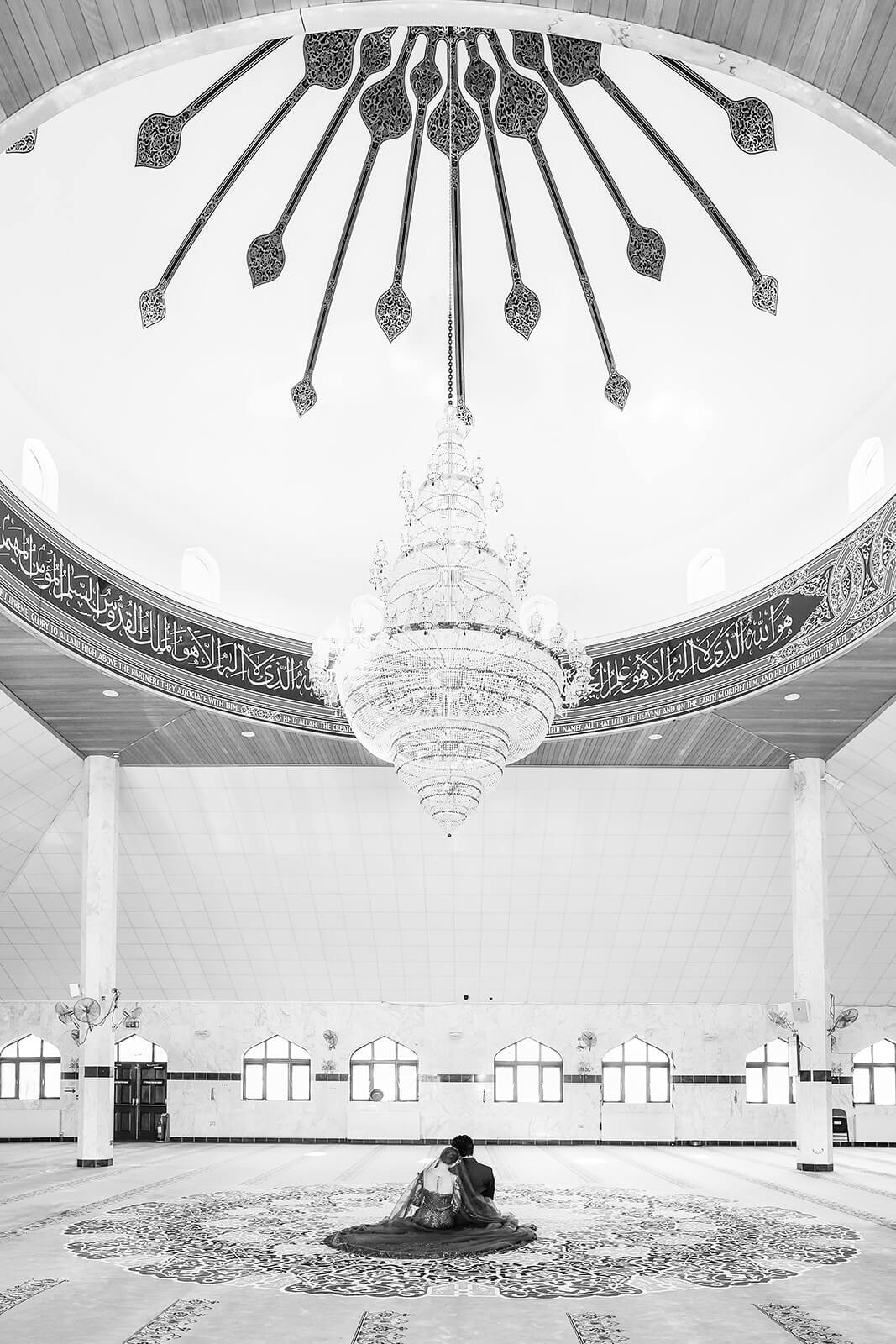 Bride and groom couple sitting in ornate mosque interior at Oxford Central Mosque