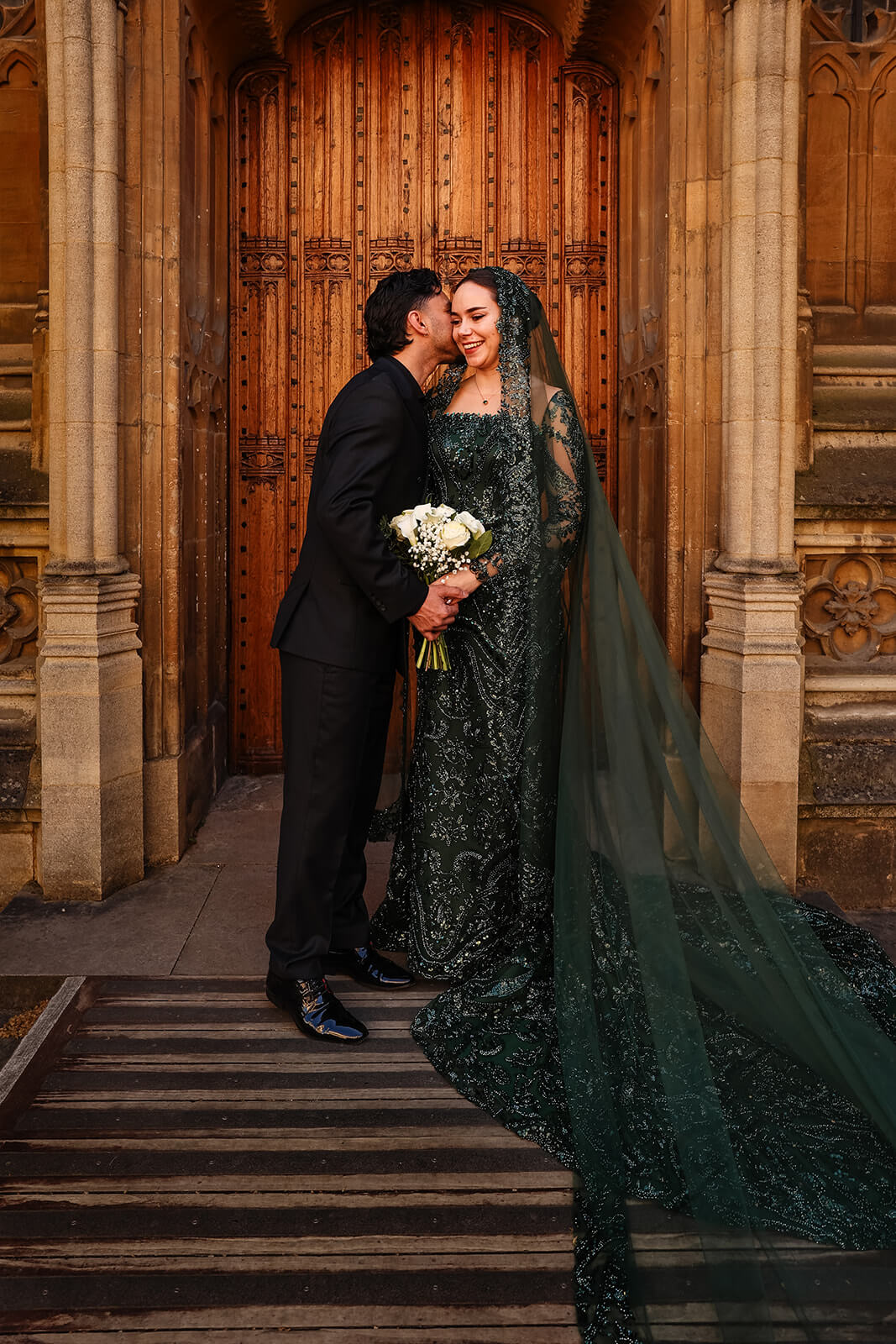 Bride and groom in Nikkah attire by ornate doorway | Oxford Nikkah Wedding Photos