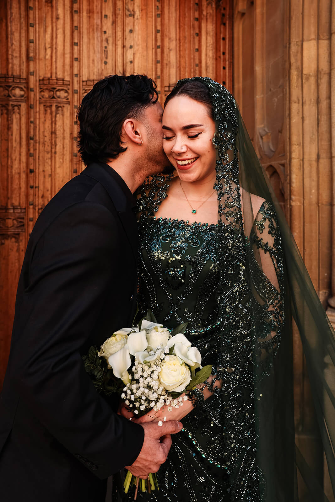 Bride and groom in Nikkah attire by ornate doorway | Oxford Nikkah Wedding Photos
