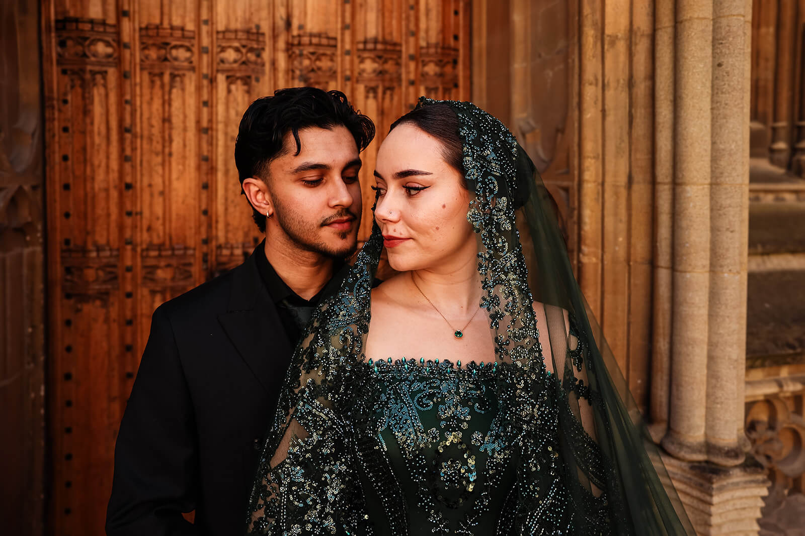 Bride and groom in Nikkah attire by ornate doorway | Oxford Nikkah Wedding Photos
